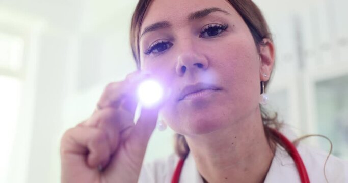 Doctor checks reaction of patient pupils with flashlight