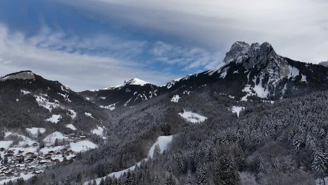 Circular shot of mountain summit from valley of pines with snow, Bernex