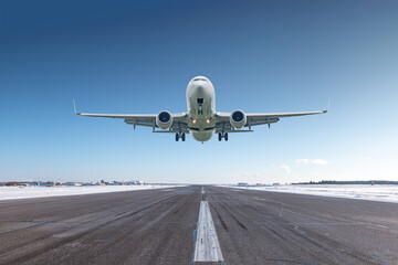 Fototapeta na wymiar White passenger airliner take off airport runway at winter