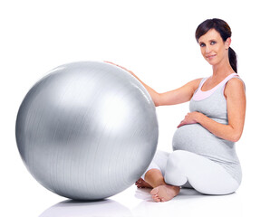 Pregnant female person, ball and studio for final trimester, wellness and exercise for motherhood. Maternal woman, workout and white background for health, fitness and pregnancy to keep in shape