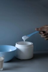 hand holding a spoon of massause lotion