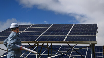太陽光発電施設を点検するエンジニア