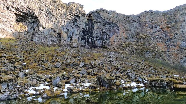 Asbyrgi canyon in Iceland, Botnstjorn glacial lake with volcanic rock formations and vertical cliffs, stones overgrown with moss.