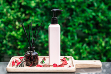 A a pink skincare lotion bottle on wooden tray with nature background