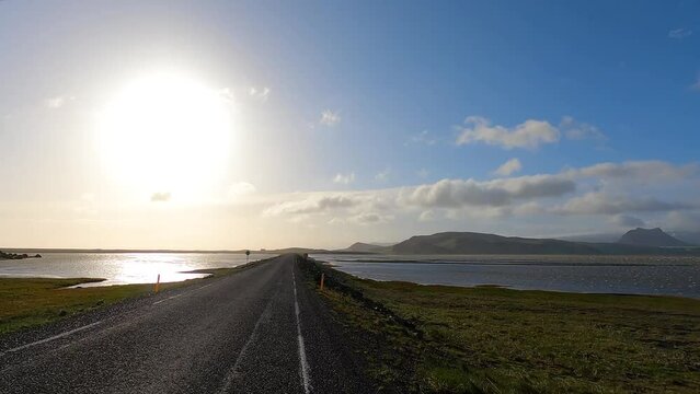 Driving on Ring Road causeway across Lonsfjordur lagoon in Iceland