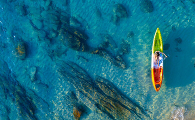 Aerial view of a kayak in the blue sea .Woman kayaking She does water sports activities.	
