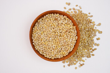 Dry pearl barley in the wooden bowl concept background
