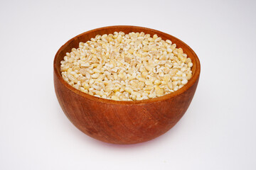 Dry pearl barley in the wooden bowl concept background
