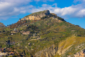 Mountains landscape over Taormina and Castelmola with Monte Ziretto peak on Ionian sea shore in Messina region of Sicily in Italy - 747806939