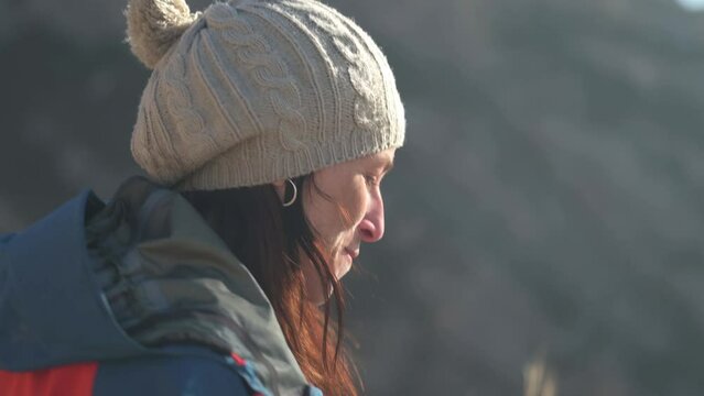 Scene of a girl in a woollen hat smiling.