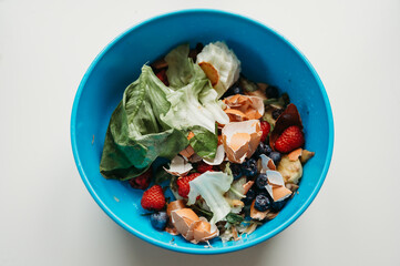 Blue bowle of food waste fruit and vegetables on a white table