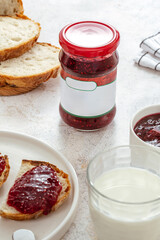 raspberry jam in a jar. bread with jam on a plate