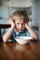 Young Boy with Hands on Head waiting for Breakfast at Kitchen Ta