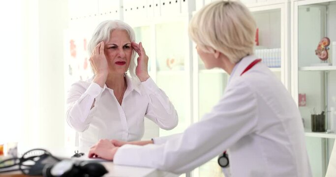 Elderly woman patient complaining of Elderly woman patient complaining of headache and memory loss to neurologist doctor in clinic 4k movie slow motion.