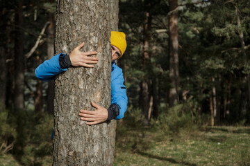 Man hugging the trunk of a tree. Conservation of the environment. international planet day