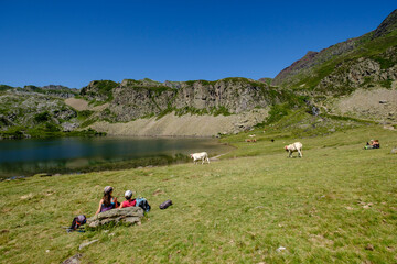 Fototapeta na wymiar hikers resting on Lac du Miey, Ayous lakes tour, Pyrenees National Park, Pyrenees Atlantiques, France