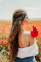 Naklejka premium Woman poppies field. Side view of a happy woman with long hair in a poppy field and enjoying the beauty of nature in a warm summer day.