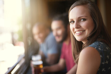 Portrait, smile and a woman at pub to relax, cheerful or positive facial expression for leisure at restaurant. Face, bar or happy female person or young customer in casual clothes at cafe for alcohol - obrazy, fototapety, plakaty