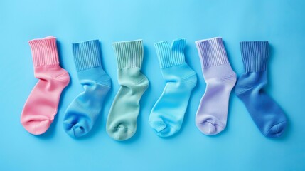 Colorful socks on a blue background. The socks are arranged in a row, with each sock a different color.