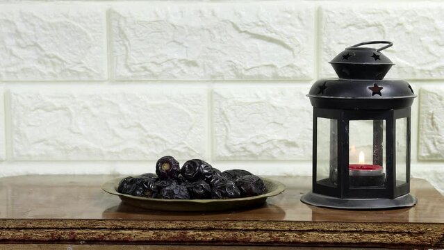 concept of the holy month of Ramadan, Classic lantern with candle and dates fruits on wood table, women eating dates 