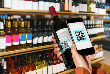 Unrecognisable customer using phone for scanning digital label of wine bottle.