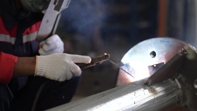 professional workers weld the poles. stainless steel pole welding. a welder welds an iron pole