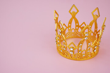 Gold princess crown on pink background, copy space for text.  © Valerii Evlakhov