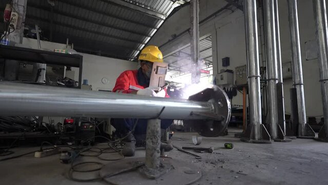 time lapse view of workers welding. the welder welds the iron pole