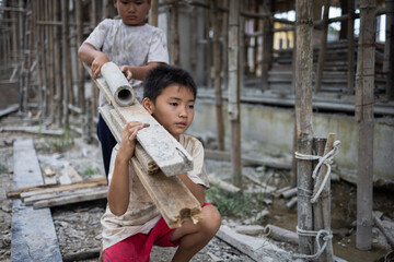 Poor boy working on a construction site. anti child labor Abuse, oppression or coercion, forced...