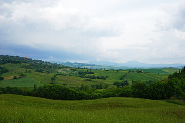 Fototapeta na wymiar Natural Tuscany landscape of green mountain hill range and view of cloudy blue sky- Florence, Italy