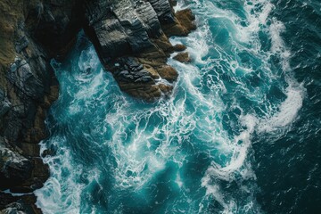 An aerial photograph showcasing the expansive ocean and rugged rocks along the shoreline in, Stunning overhead shot of sea waves dancing around sharp rocks, AI Generated