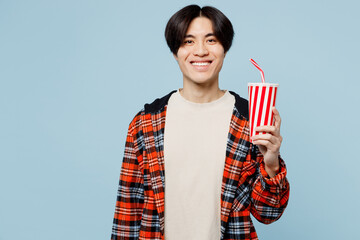 Young satisfied cool fun man of Asian ethnicity he wears red hoody casual clothes hold in hand cup...