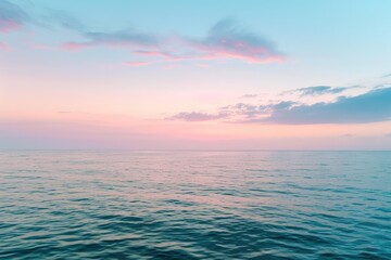 Fototapeta premium A photograph showing a vast body of water reflecting the colors of a cloudy sky at sunset, Subtle hues of a dusk sky over an open ocean, AI Generated
