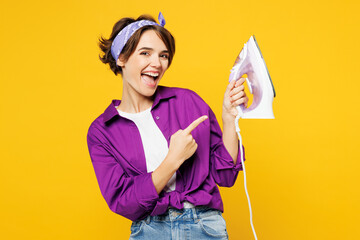 Young smiling cheerful happy fun woman she wear purple shirt do housework tidy up hold in hand...