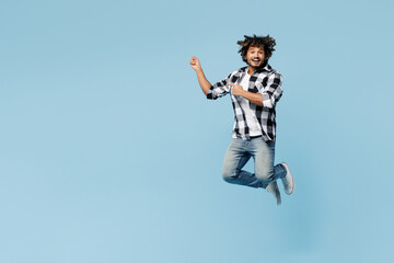 Obraz premium Full body young Indian man wears shirt white t-shirt casual clothes jump high point index finger aside on area isolated on plain pastel light blue cyan background studio portrait. Lifestyle concept