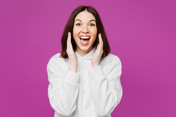 Young smiling happy Caucasian woman she wear light hoody casual clothes scream sharing hot news about sales discount with hands near mouth isolated on plain purple color background. Lifestyle concept.