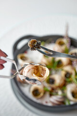 Dijon-style baked Escargot snail are taken out of the shell