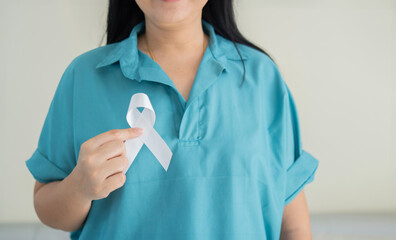 Healthcare and medicine concept. female hands holding white ribbon. Lung cancer awareness.