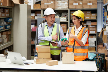 factory workers checking products from clipboard and cardboard box packaging in the warehouse...