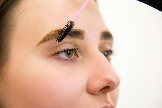 make up artist applying special paint for coloring eyebrows in beauty salon. Permanent make up