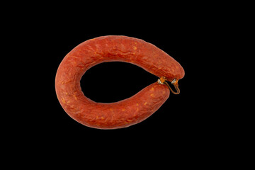 ring of semi-smoked sausage isolated on a black background top view