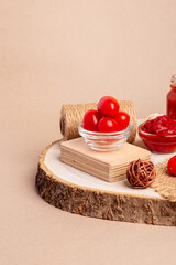 Cherry tomatoes and tomato paste on a wooden desk on a light beige background.