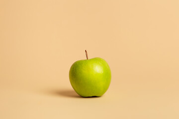 Green apple on a beige background.