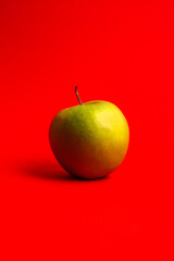 Green apple on a red background.