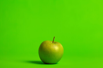 Granny smith apple on a green background.