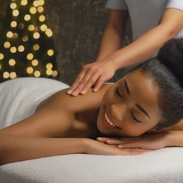 Woman receiving back aromatherapy treatment in a relaxing space