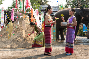 Naklejka premium Thai women in traditional Thai costumes gathering Song Kran festival in chiangmai , Thailand