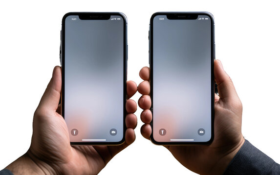 A pair of hands are shown holding two Phones, one in each hand, against a plain white background. The phones are prominently displayed in the center, with the hands firmly gripping the devices.