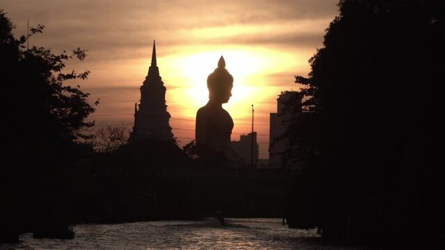 The peaceful beauty of the evening sunset.The Giant Buddha Statue at the Wat Paknam Phasi Charoen temple in Bangkok, Thailand,