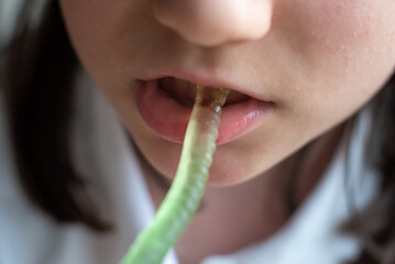 Schoolgirl Eating Gummy Worms Candy: Close-Up of Mouth